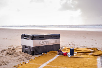 85L The Adventurer - Dual Zone myCOOLMAN fridge on beach beside picnic blanket